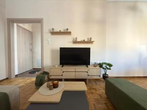 a living room with a flat screen tv and a couch at Benoikon House With Free Private Parking in Serres
