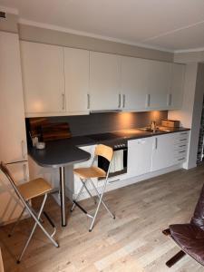 eine Küche mit weißen Schränken und einem Tisch und Stühlen in der Unterkunft My Little Boat House in Oslo