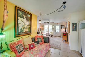 ボニータ・スプリングスにあるBoho-Style Escape with Patio about 3 Mi to Bonita Beach!のソファと壁に絵が飾られたリビングルーム