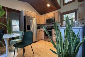 a kitchen with a refrigerator and a table and a plant at Lake Zoar Cabin in Newtown