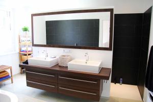 a bathroom with two sinks and a large mirror at Casa Cambodunum in Kempten