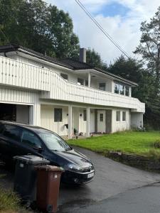 a black car parked in front of a house at Hybel hauslia kristiansand in Kristiansand +8 photos