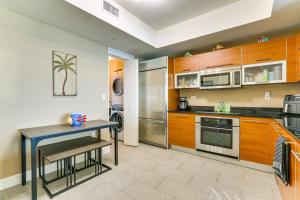 a kitchen with wooden cabinets and a small table in it at Heated Pool Access! Waterfront Fort Myers Condo in Fort Myers