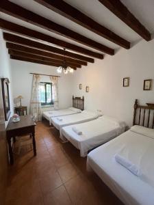 a group of four beds in a room at Casa La Vega in Colmenar de Oreja