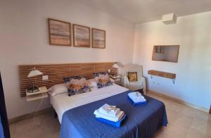 ein Schlafzimmer mit einem Bett und einem Stuhl darin in der Unterkunft Apartamento Alcazar in Almuñécar + 29 Fotos