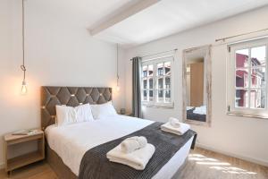 a bedroom with a large bed with towels on it at Largo da Praça Boutique by Sé Apartamentos in Braga