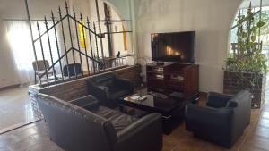 a living room with couches and a tv at La Cascada Country Club in Pilar