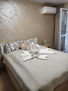 een slaapkamer met een groot bed met witte kussens bij Апартамент Дар in Belogradchik