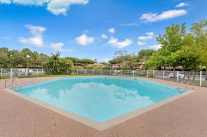 a large swimming pool with blue water at Le Jardin des Muses - T3 climatisé avec terrasse, Piscine et Parking in Toulouse