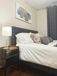 a bedroom with a bed and a table with a lamp at The Harrison Apartments in Evansville