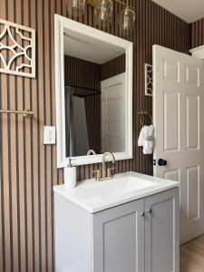 a bathroom with a sink and a mirror at The Harrison Apartments in Evansville +26 photos