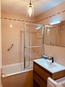a bathroom with a shower and a sink and a tub at Le Louisiane in Le Touquet-Paris-Plage