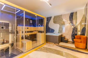 a room with a shower with an orange chair at VBM Suite & SPA Apartments in Bari