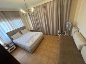 een slaapkamer met een wit bed en een bank bij Villa Reina 2 in Alexandroupoli