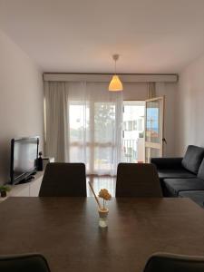 a living room with a table and a tv at Ohana Funchal in Funchal