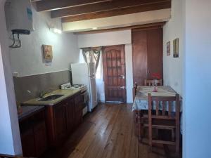 eine Küche mit einer Spüle, einem Kühlschrank und einem Tisch in der Unterkunft clara mar in Santa Clara del Mar