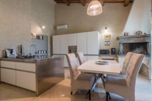 a kitchen with a table and a kitchen with a fireplace at Villa Margot in Stazione delle Pole-Piobbico