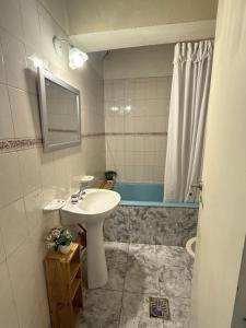 een badkamer met een wastafel en een ligbad bij En el centro Luz II in Río Gallegos