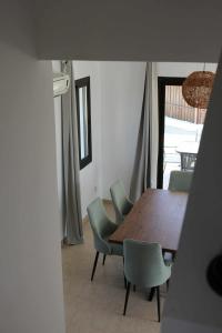 a dining room with a wooden table and green chairs at Casa Elea in Kouklia