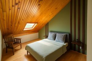 a bedroom with a bed and a wooden ceiling at Gite etape chez Paule et jo in La Possession +4 photos