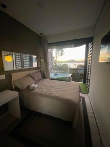 a bedroom with a bed and a window with a tub at Casamar paraíso na praia com a vista do mar dos sonhos piscina e spa in Guarujá +43 photos