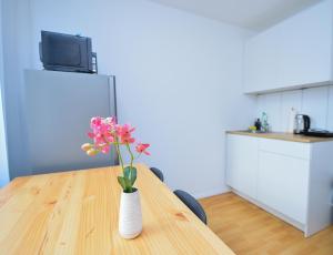 a vase of flowers sitting on a wooden table at Apartment Hotel in Nuremberg