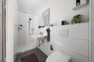 a white bathroom with a toilet and a sink at MINZ Studios in Bremen +13 photos