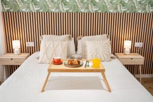 a bed with a tray of food on a table at Loft Familiar Paz y Conexión Ideal en Valencia in Valencia