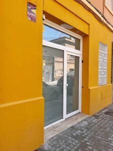 a yellow building with a sliding glass door at Loft Familiar Paz y Conexión Ideal en Valencia in Valencia