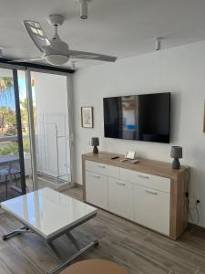 a living room with a tv and a glass table at 6 building Aloe - Free WiFi, Central, near playa dunes in Maspalomas