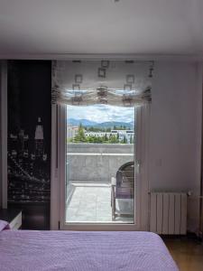 a bedroom with a window with a view of a balcony at Apartamento Carmen y Adolfo in Laredo
