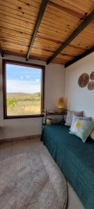 a bedroom with a bed and a large window at Vila Prana - Chalé Paz - privacidade e vista infinita in Alto Paraíso de Goiás