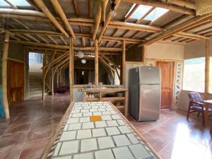 a kitchen with a refrigerator and a table at Casa Bambú Veracruz in El Zapote