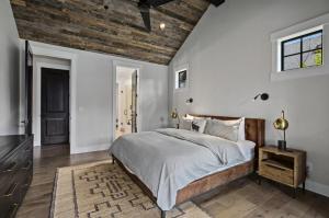 RoslynにあるLucky Elk Lodge in Suncadia- Fairway View, Hot Tub BBQ, Firepit, Game Room, Chefs Kitchen, Hi-speed Wi-Fiの木製の天井が特徴のベッドルーム1室(ベッド1台付)