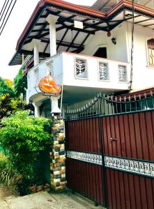 ein Haus mit einem roten Zaun und einem Tor in der Unterkunft Dream Villa in Batigama