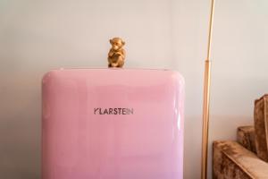 a toy monkey sitting on top of a pink flask at goldfinger + suites in Lana