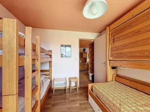 ein Schlafzimmer mit zwei Etagenbetten und einem Schreibtisch in der Unterkunft Appartement confortable au pied des pistes avec accès piscine chauffée - FR-1-267-229 in Le Corbier