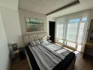 a bedroom with a bed and a large window at Bright and Cosy Home in Szentendre in Szentendre