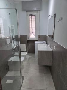 Un baño con lavabo, bañera e inodoro. en Ceriale Suite, en Ceriale