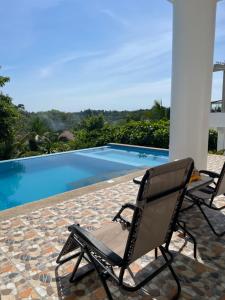 two chairs sitting next to a swimming pool at Couple room B in Final Destination Resort in Bolinao +18 photos