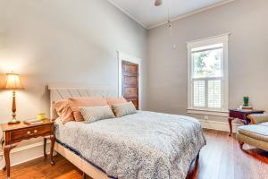 ein Schlafzimmer mit einem Bett und einem Stuhl und einem Fenster in der Unterkunft Walk to McDonough Square Historic Home with Yard! in McDonough + 29 Fotos