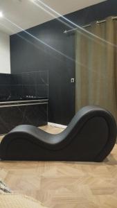 a black couch sitting on the floor in a room at Chez sousouzen in Dunkerque