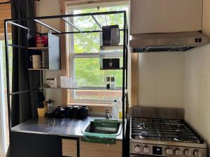 a small kitchen with a stove and a window at Ananda - Enchanted Forest Hideaway in Pleasant Bay