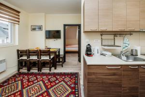 a kitchen and a dining room with a table at Apartman No.32a-JollyKop in Kopaonik