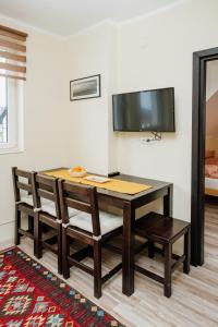 a dining room table with chairs and a flat screen tv at Apartman No.32a-JollyKop in Kopaonik