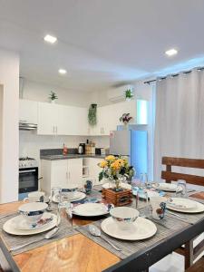 una cocina con una mesa con platos y flores. en Jodies Place Near Airport Cozy Homestay, en Puerto Princesa City
