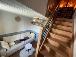 a living room with a couch and a staircase at Détente Normande in Branville