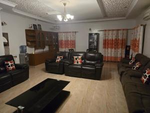 a living room with black leather couches and a table at 3 bedroom fully furnished bnb in Eldoret