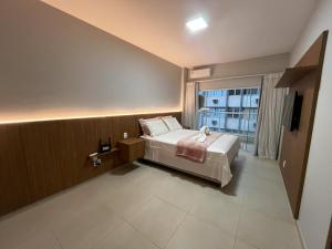 a hotel room with a bed and a window at Areia Flat vista mar piscina e ar in Guarapari +53 photos