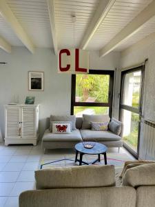 ein Wohnzimmer mit zwei Sofas und einem Couchtisch in der Unterkunft L'Abri du Rouget, 5 minutes à pied de la plage du Trez-hir, vacances en famille in Plougonvelin